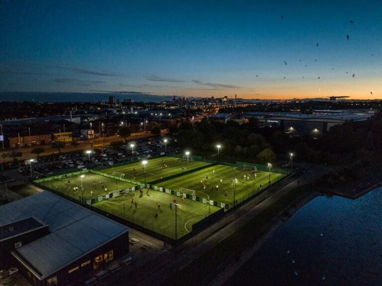 Powerleague Paisley – night-time aerial view of illuminated 5-a-side football pitches in a modern sports facility